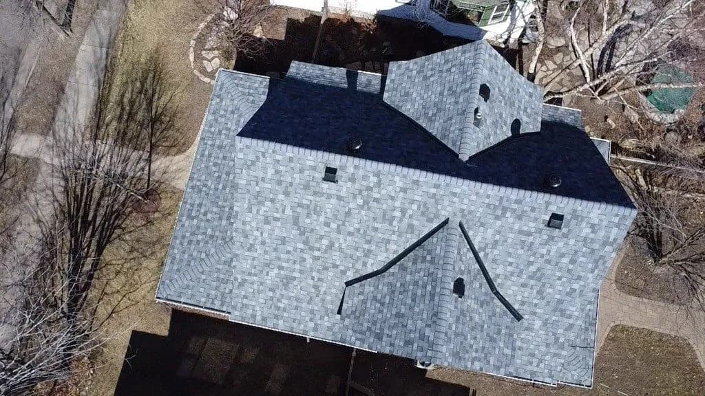 Aerial view of a two-story home with a newly installed gray architectural shingle roof