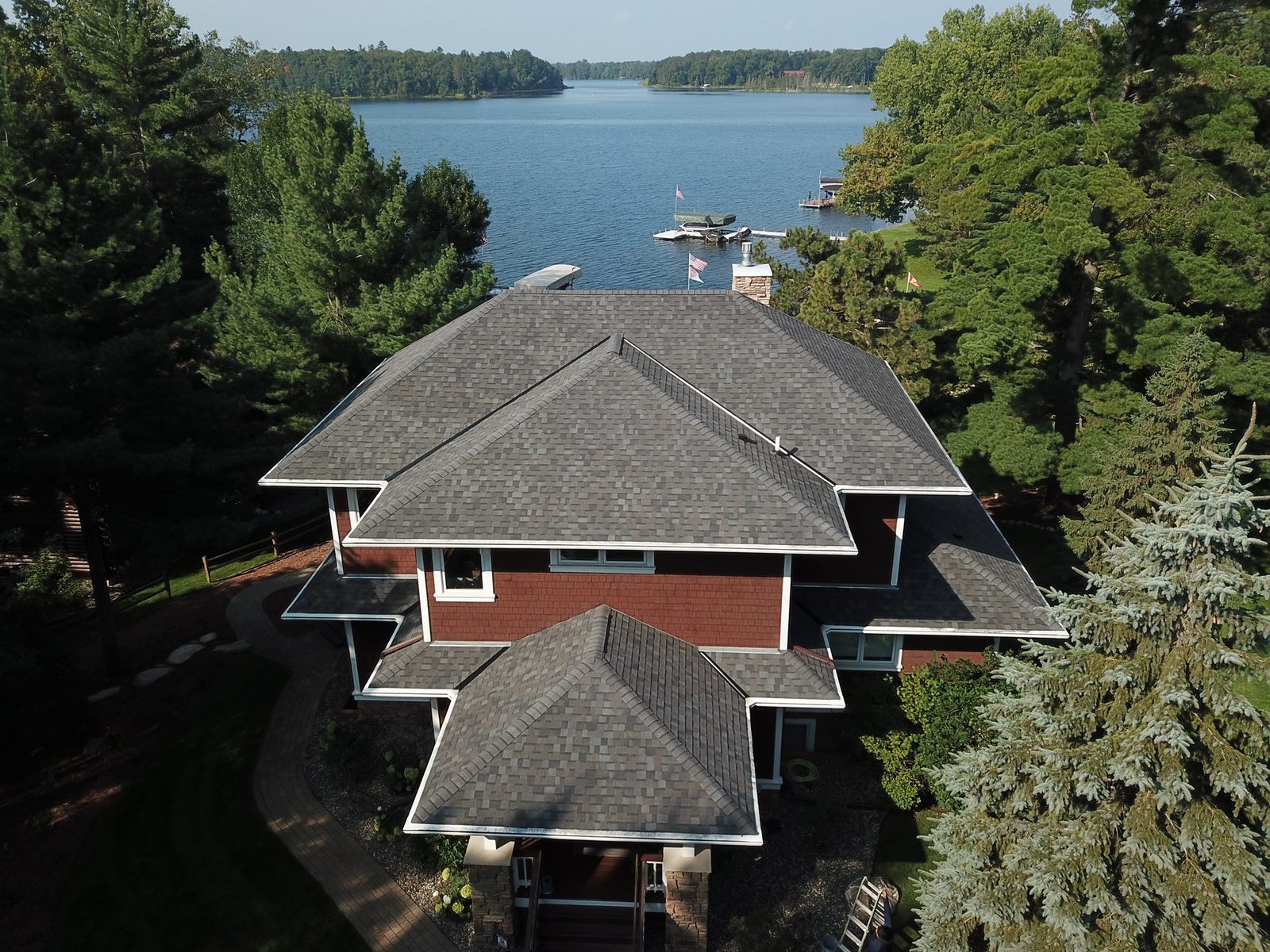 Aerial drone view of a lakefront Minnesota home with a new gray architectural shingle roof