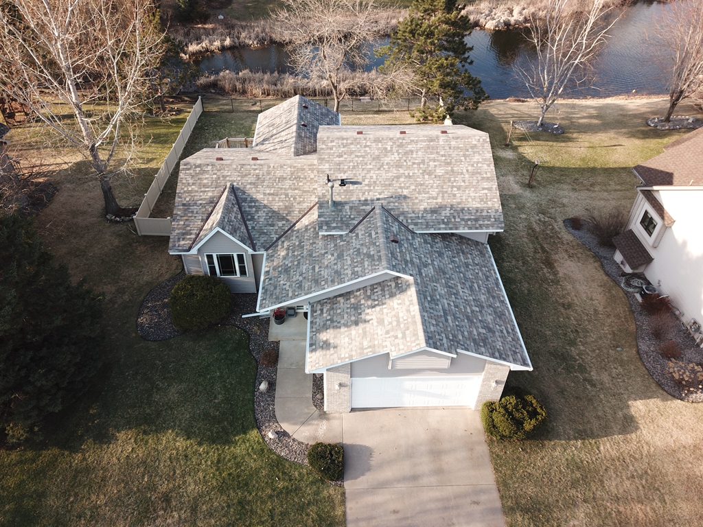 Aerial drone view of a lakeside rambler with a newly installed gray architectural shingle roof