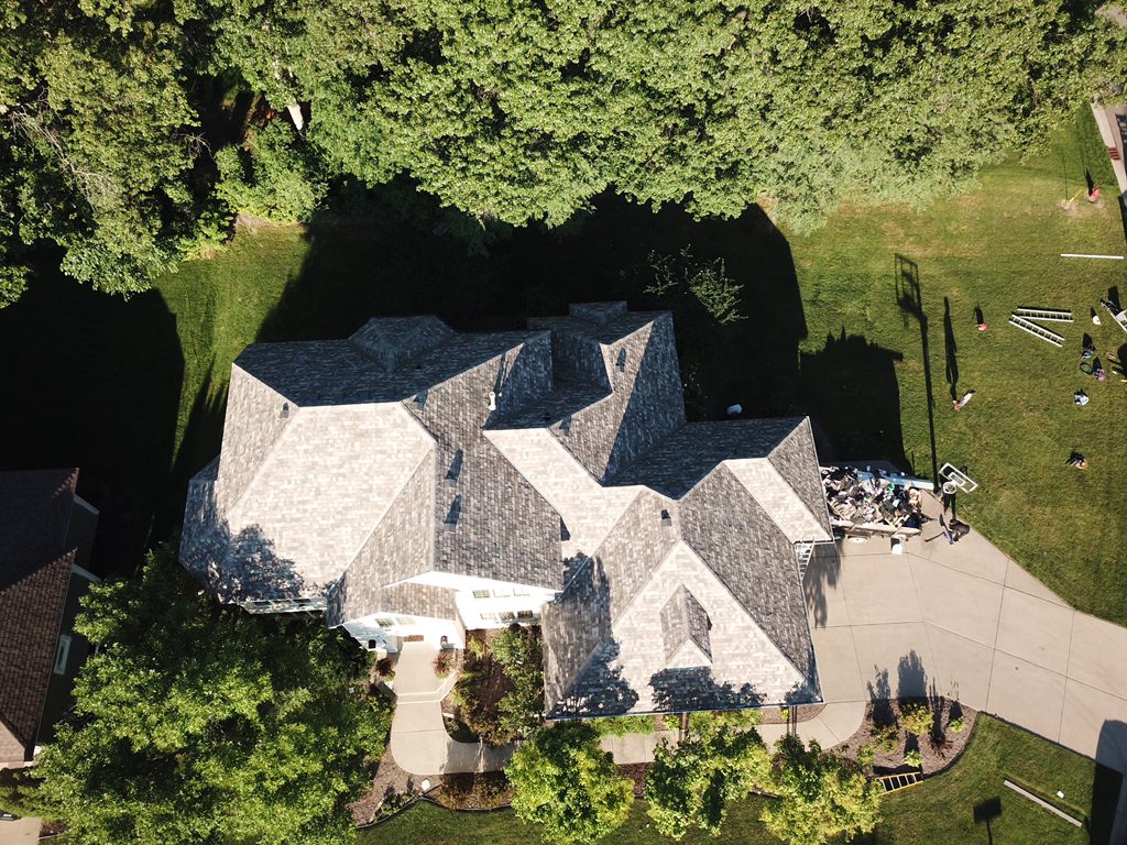Aerial drone view of a multi-gable home with a newly installed architectural shingle roof