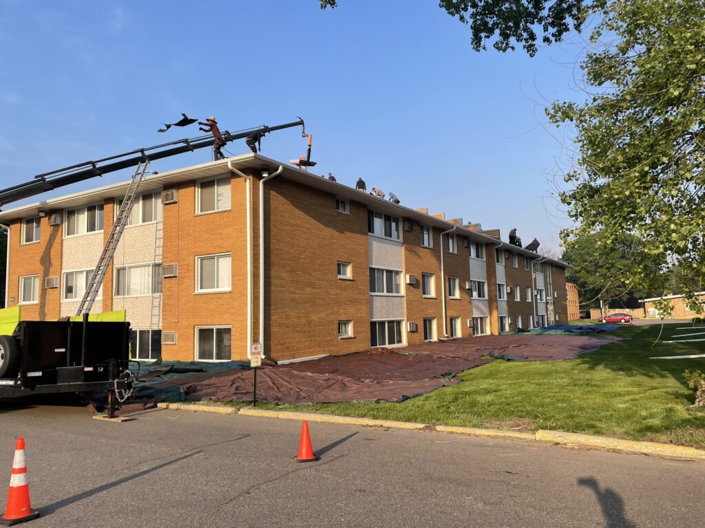 Roof R Us workers replace the roof on a multifamily commercial building