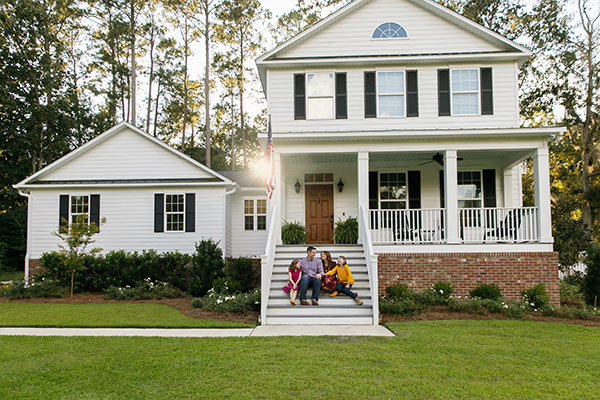 Happy family sitting on their home steps after financing their roof