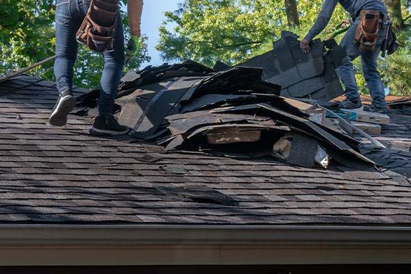 Roofers work to repair a roof after extensive storm damage in Crosslake, MN.