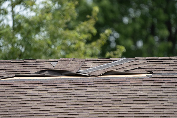 Damaged brown shingled roof