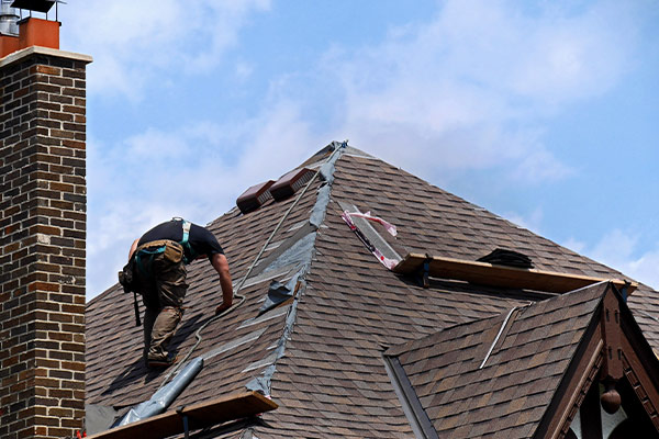 Roofs R Us roofing expert fixing shingles on a brown roof during a roof repair job in Minnetonka