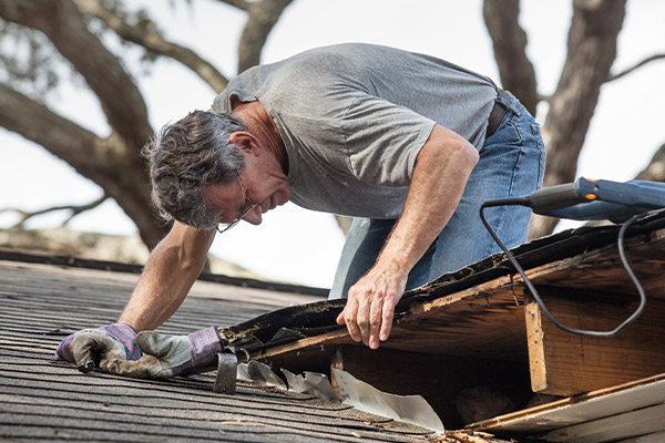 Man inspecting his roof after a severe storm in Edina, MN