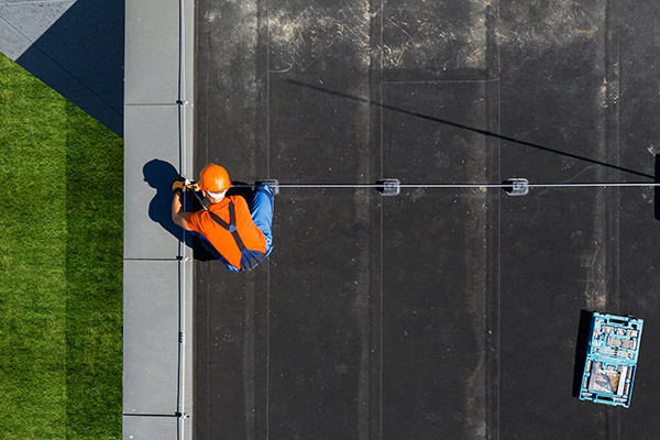 Roofs R Us worker fixing a commercial roof in Ham Lake, MN