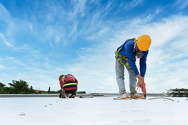 Two commercial roofing experts installing a commercial roof in Minnesota