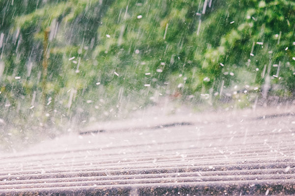 Hail hitting a brown roof during a hail storm in Minnesota