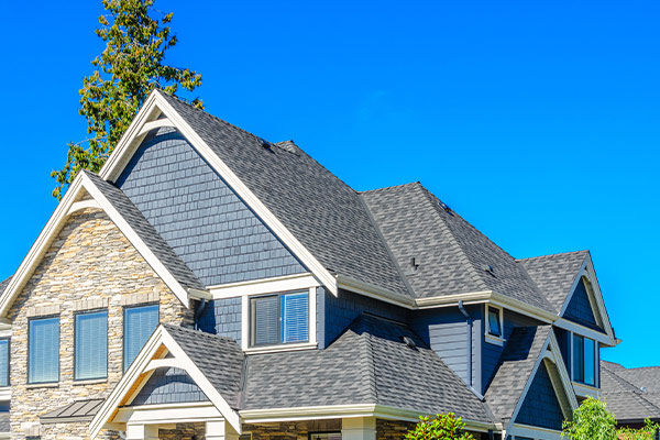 a house with a tree in the background after roof installation in Maple Grove, mn