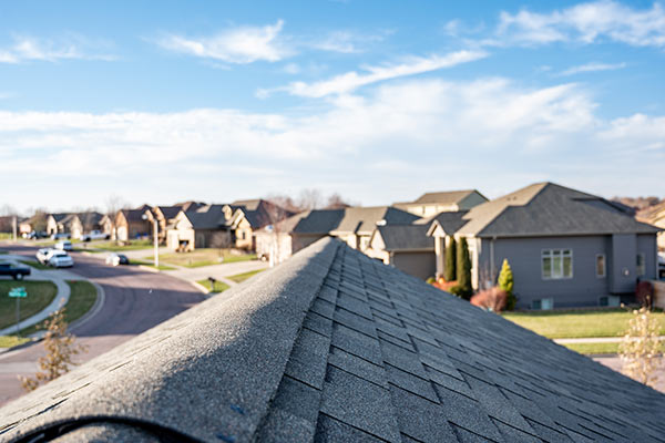 top view of a gray roof and other houses with gray roofs in the distance